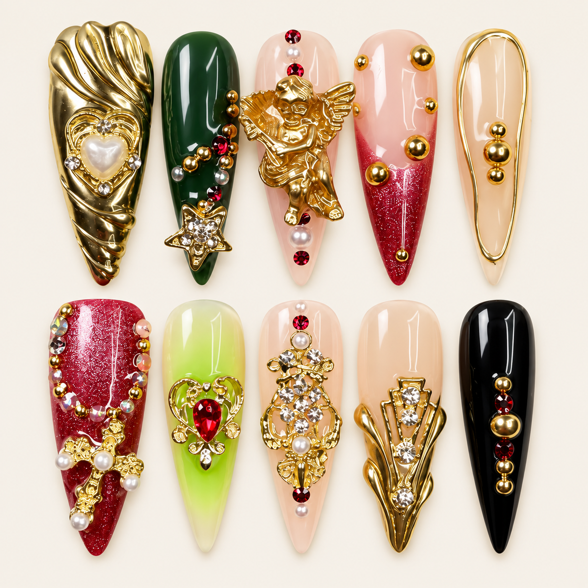 10 press-on nails Ruby longs et pointus, rouges, verts, noirs et roses, avec ange doré, cœurs, croix, perles et pierres décoratives sur fond ivoire.