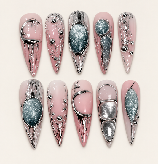 10 press-on nails Mercure longs et pointus, rose nude avec reliefs chromés argentés et décors vert profond scintillants sur fond ivoire.