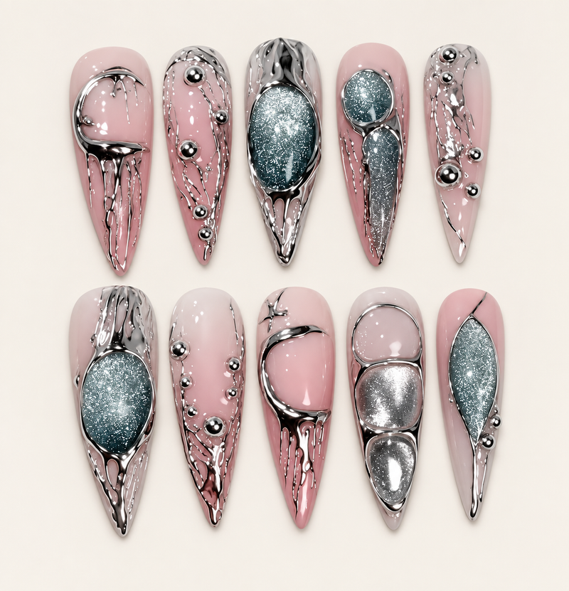 10 press-on nails Mercure longs et pointus, rose nude avec reliefs chromés argentés et décors vert profond scintillants sur fond ivoire.