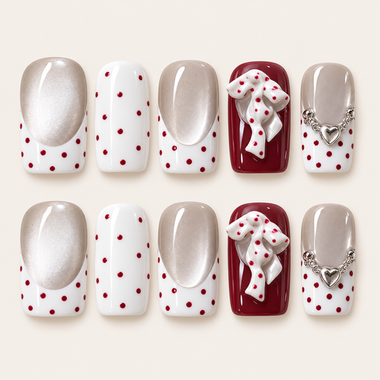 10 press-on nails Rubéa à pois rouges, French blanche sur base champagne, nœuds 3D sur fond bordeaux et cœurs argentés.